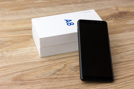 February 2018. Samsung Galaxy A8 lies on a wooden table. A new smartphone from the company Samsung close-up on a wooden surface.のeditorial素材