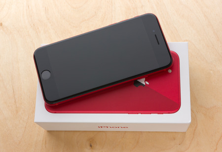 May 2018. Apple iPhone 8 (PRODUCT) RED and box lies on a wooden table. A new smartphone from the company APPLE close-up on a wooden surface.のeditorial素材