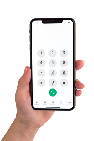 Rostov-on-Don, Russia - November 2018. Apple iPhone XS Max 6.5-inch display in hand on a white background. Smartphone iPhone XS Max Gold in hand with an open dialing menu on a white background.のeditorial素材