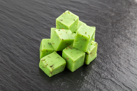 Cheese cubes of green color on a slate board. Cheese pesto closeup on the surface of the stone.の写真素材