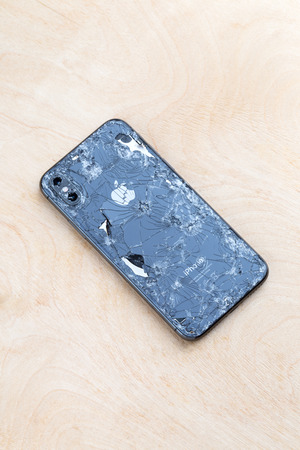 Rostov-on-Don, Russia - December 2018.  Broken iPhone XS lies on a wooden surface. New smartphone from the company Apple broken on a wooden table.のeditorial素材