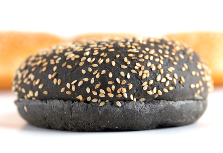 Burger buns on white background. A few buns cut in half close up on a white background. One black burger closeup.の写真素材