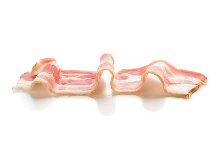 A slice of bacon on a white background. One raw bacon closeup on a white background.の写真素材