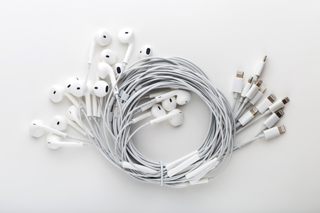 Headphones on a white background. Lots of headphones coiled together on a white background.の写真素材