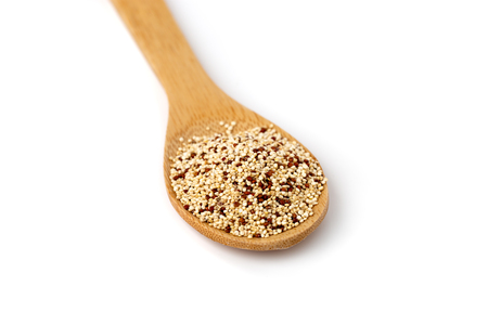 Quinoa in a spoon close-up. Quinoa in a wooden spoon on a white background.の写真素材