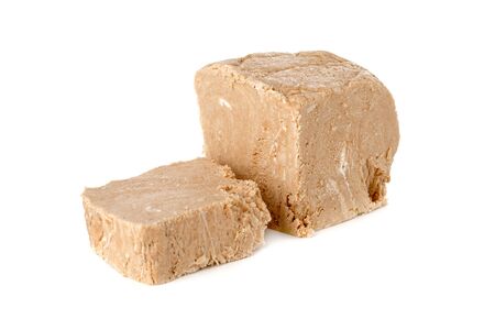 Halva on a white background. Arabian sweetness of caramel mass and ground roasted kernels of nuts, peanuts, close-up.の写真素材
