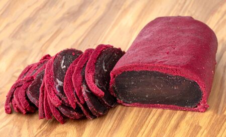 Cured meat on a wooden board. Close-up of basturma sliced into pieces.