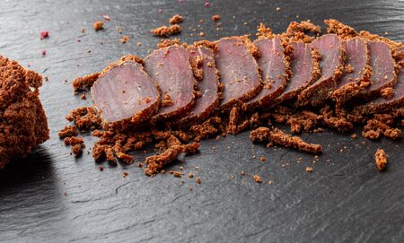 Cured meat on a slate board. Close-up of basturma sliced into pieces.の写真素材