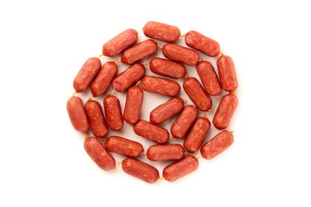 Small smoked sausages on a white background. Grilled sausages close-up on a white background. Top view.の写真素材