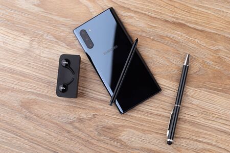Rostov-on-Don, Russia - December 2019. Samsung Galaxy Note 10 on a wooden table. Smartphone, stylus,...