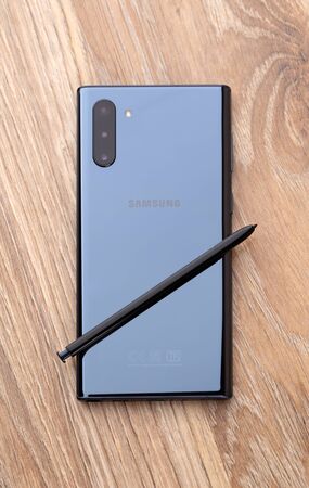 Rostov-on-Don, Russia - December 2019. Samsung Galaxy Note 10 on a wooden table. Smartphone and stylus close-up.のeditorial素材