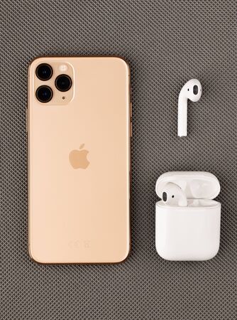 Rostov-on-Don, Russia - october 2019. Apple iPhone 11 Pro on a grey surface. New smartphone from the company Apple close-up. Smartphone and AirPods earphones.のeditorial素材