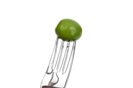 Pickled olive impaled on a fork on a white background. Pickled green olive on a fork closeup.の写真素材