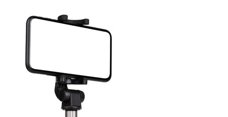 Smartphone with a white cut-out screen on a monopod. Selfie stick and smartphone on a white background.の写真素材