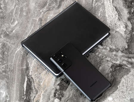 Rostov-on-Don, Russia - February 2021. Samsung Galaxy S21 Ultra 5G on a marble table. A new smartphone from Samsung and a diary book close-up.のeditorial素材