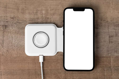Smartphone on wireless charging on the table. Smartphone is being charged on wireless charging...