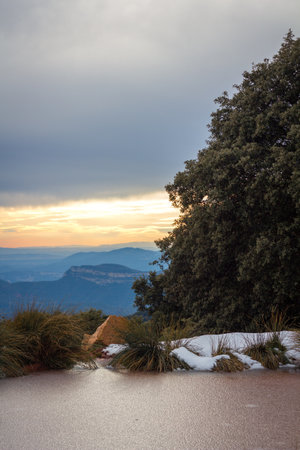 frozen lake in pla de la calma catalonia spain with cloudy sky and sunset sun with monte del tagamanent in the backgroundの写真素材