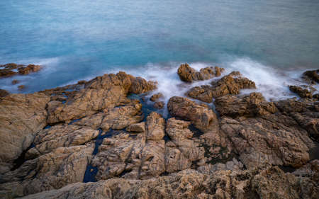top view of rocky coastline with waves crashing against it at sunset and silk effect, blanes catalonia spainの写真素材