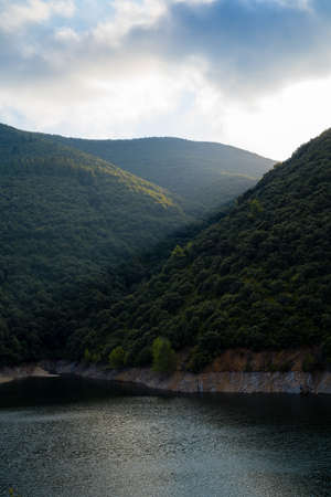 Vallfornis reservoir with a ray of light crossing it and stormy clouds in the background, canoves and samalus Catalonia, Spainの写真素材