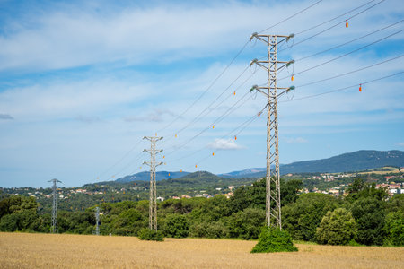 high voltage towers in wheat field at sunset in cloudy sky, Catalonia, Spainの写真素材