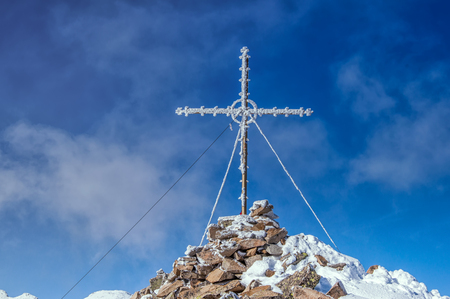 The frozen cross at the top of the mountainの写真素材