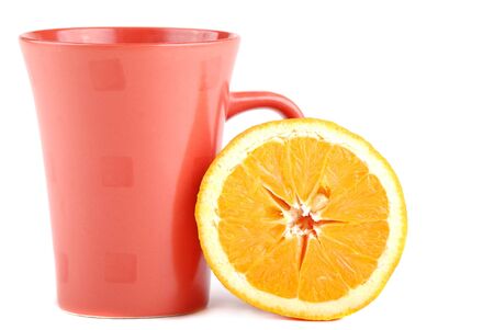 Colour cup and the fresh cut orange near to it.の写真素材