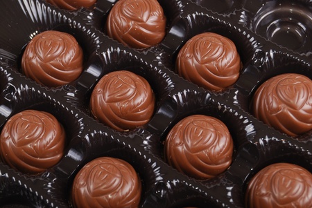 Chocolates in a box of black colour. A dessert.の写真素材