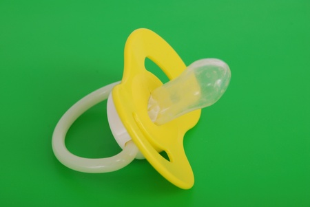 Children's dummy from plastic and rubber on a green background