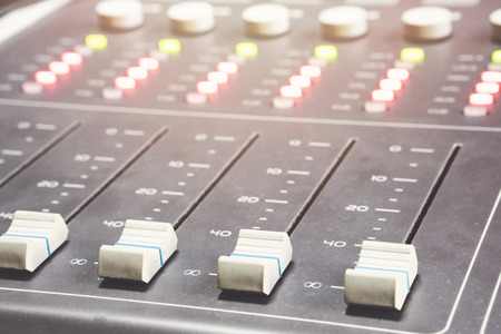 Professional audio mixing console with faders and adjusting knobs - radio / TV broadcasting