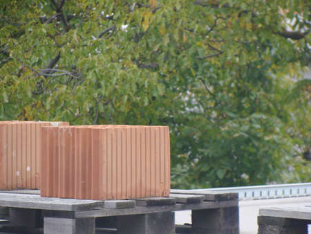 Two piles of brick on the roof stansing on the pallet.の写真素材