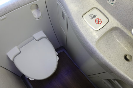Interior of an airplane with a toilet and washbasin.