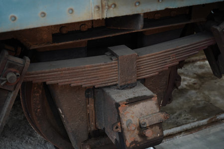 Close-up of old rusty vehicle leaf spring suspension.