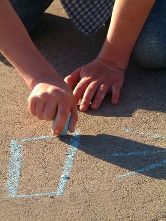 ittle girl drawing on sidewalk with chalkの写真素材