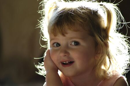 Beautiful backlit little girl with blond hairの写真素材