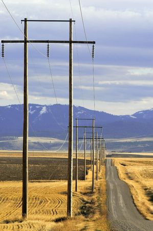 View of powerlines with road and sky in background