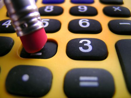 Closeup of a pencil pushing buttons on a calculatorの写真素材