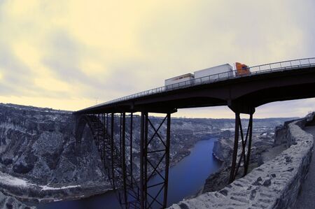Truck driving over long bridge spanning a ravineの写真素材