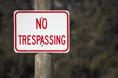 No Trespassing Sign with fence and snow in backgroundの写真素材