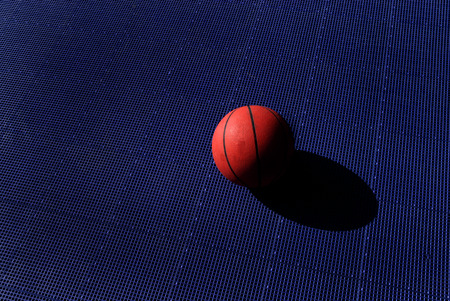 Action shot of basketball going through basketball hoop and netの写真素材