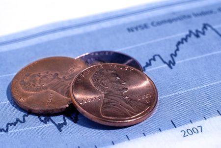 Closeup of pennies with graph and stock chart in background