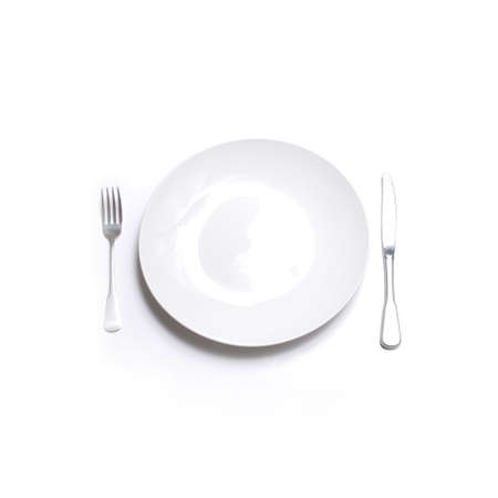 Knife and fork silverware with white plate on white backgroundの写真素材