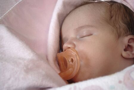Portrait of new born baby girl in a pink blanketの写真素材