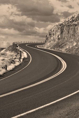 Country road with painted double yellow lines going up hillの写真素材