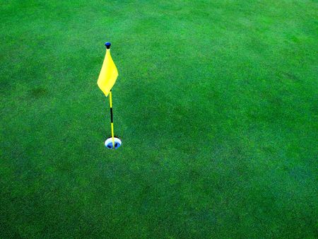 Flag and hole for golf on green grassの写真素材