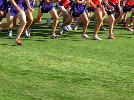 Runner running a race cross couintry on green grass fieldの写真素材