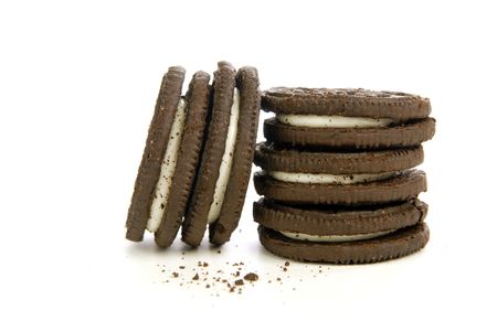 Chocolate cookies with creme filling and crumbs on white backgroundの写真素材