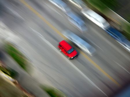 Red Car driving along road with blurred backgroundの写真素材