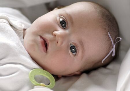 New born baby legs lying on top of white blanketの写真素材