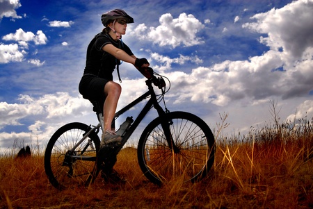 Young Woman Riding Mountain Bike in Wildernessの写真素材