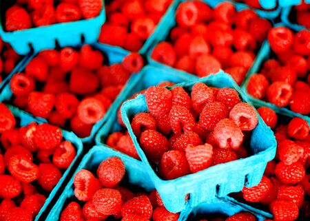 Fresh berries in bins on display for sale at the marketの写真素材